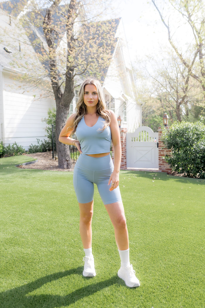 Female modeling the Bamboo Flex High Rise Biker Short in Slate paired with a matching bra tank