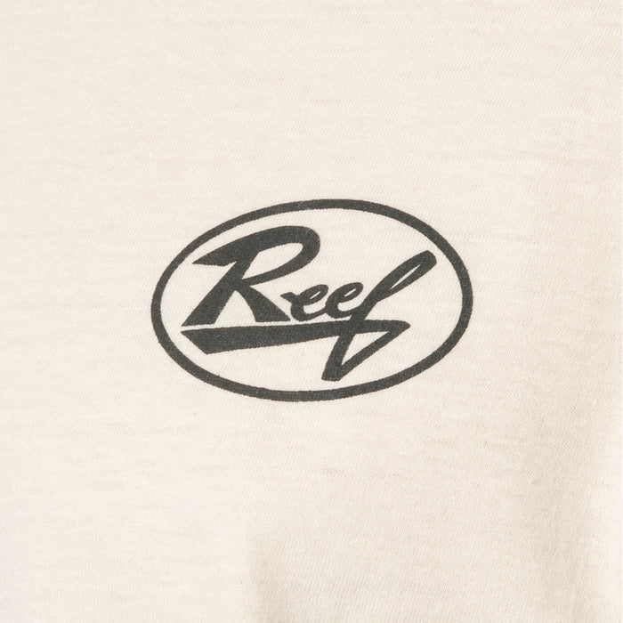 Close-up of cream-colored fabric with black Reef logo print on front of Auto Tee for men