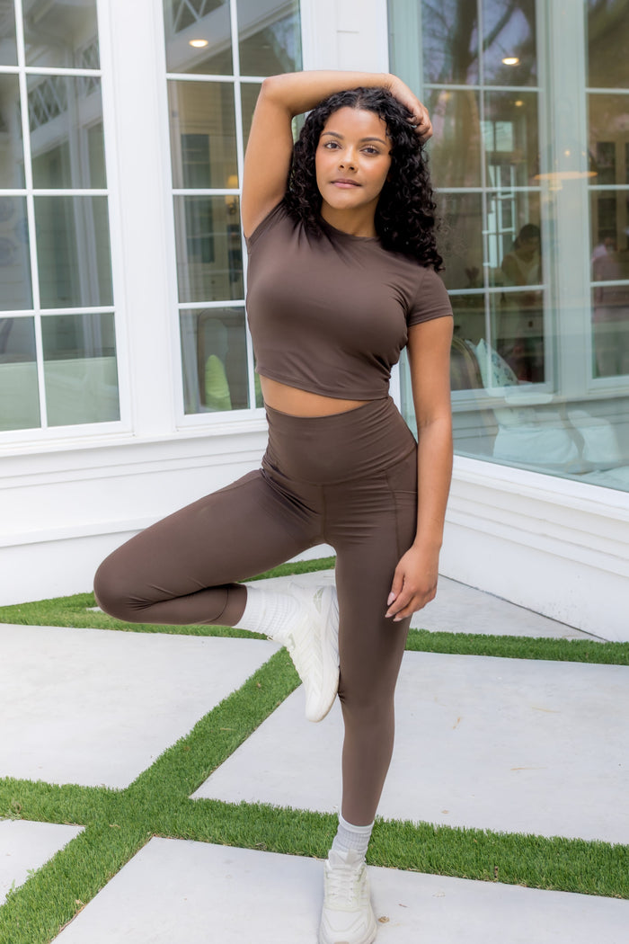 Female model posing wearing the Bamboo Flex Baby Tee in Espresso and matching leggings