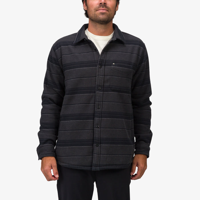Front view of man wearing Bartlett Woven Jacket with button closure, chest pocket, and striped black fabric, beach-inspired comfort.