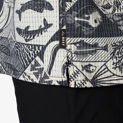 Close-up of the lower hem of the Beckham Camp Shirt showing ocean-inspired print and REEF brand tag on men's apparel.