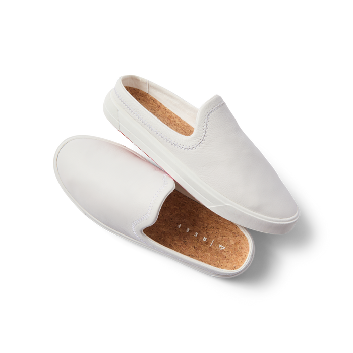 Coastal Breeze women’s white slip-on shoes facing right and top with comfort arch support and cork footbed close-up.