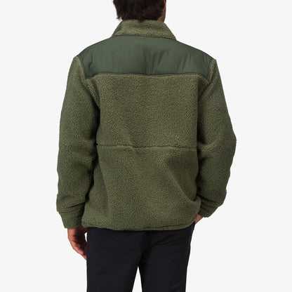 Back view of a man wearing an olive green Cooke Sherpa Jacket with a smooth shoulder panel, highlighting comfort and beach-inspired style.