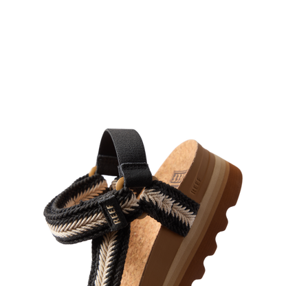 Cushion Rem Hi sandal facing left, close-up on upper with braided black and white straps and cushioned cork footbed