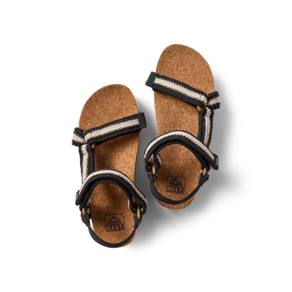 Top view of women's Cushion Rem Hi sandals with black and white braided straps and cork footbeds facing forward.