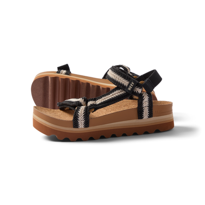 Pair of Cushion Rem Hi sandals for women facing right, braided straps, soft cushioning, and textured soles for beach comfort.