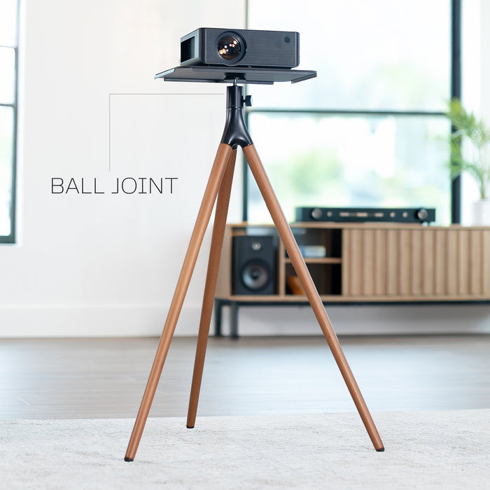 Projector on a wooden tripod in a room with furniture and decor.