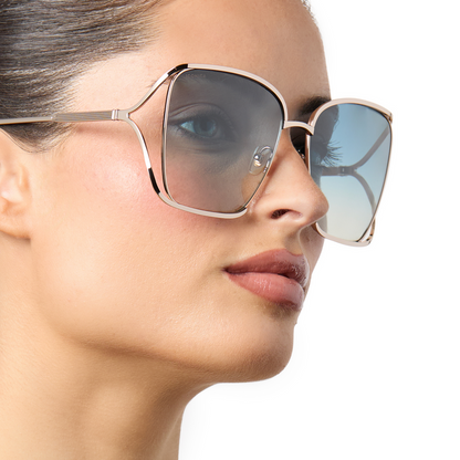 on model - female wearing iconica x diff eyewear francesca square oversized sunglasses with a champagne metal frame and paradiso blue polarized lenses angled view