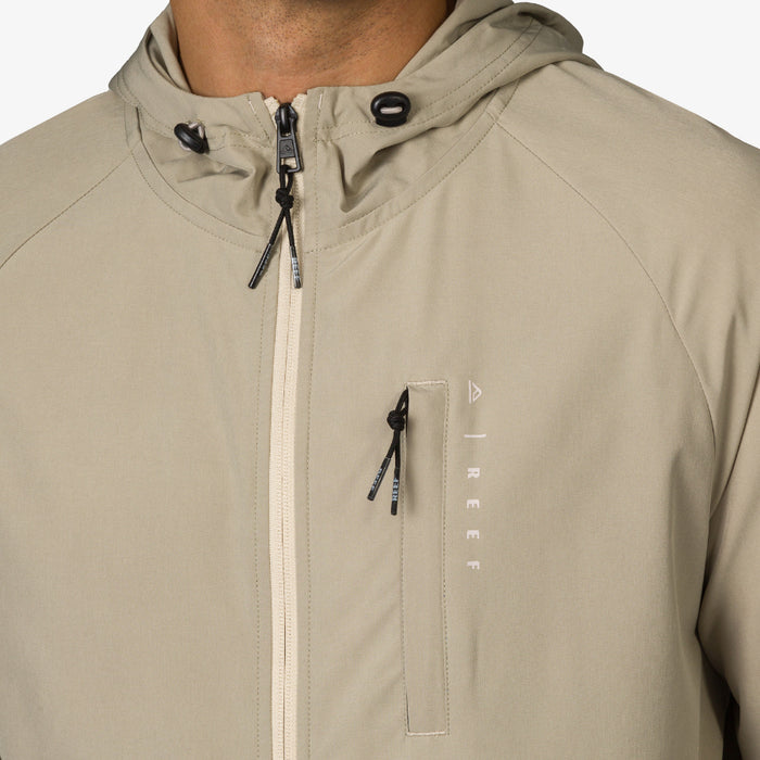 Close-up of the upper chest and hood area of the beige Garvey Jacket for men, featuring zipper and drawstring details.
