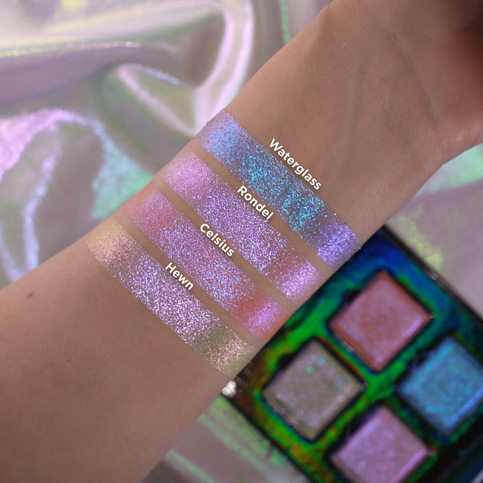 Arm swatches of all four shadows from the Glow Quad on fair skin tone with an open Glow Quad in the background.