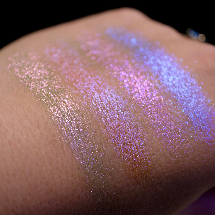 Swatches on the back of hand of all four shadows from the Glow Quad on fair skin tone with a black background.