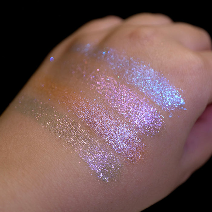 Swatches on the back of hand of all four shadows from the Glow Quad on fair skin tone with a black background.