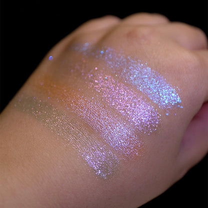 Swatches on the back of hand of all four shadows from the Glow Quad on fair skin tone with a black background.
