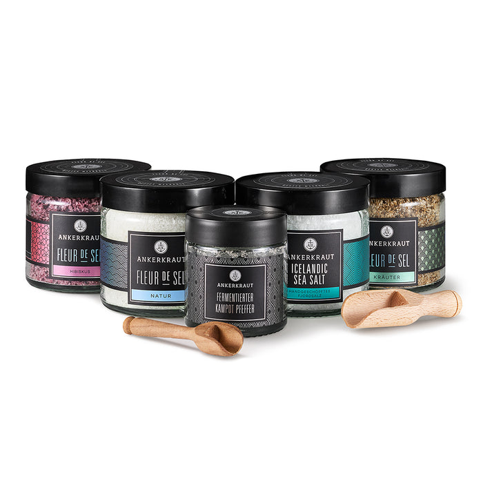 Gourmet Set mit hölzernen Gewürzlöffeln vor weißem Hintergrund.