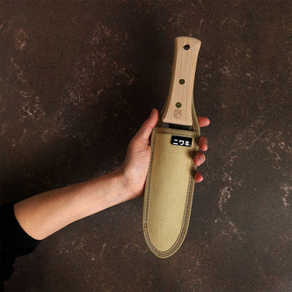 Hand holding a trowel inside canvas sheath on dark background