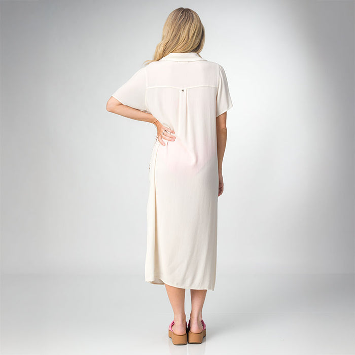 Woman wearing a cream-colored Irina Shirt Dress, shown from the back with pink platform sandals facing backward.