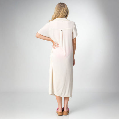 Woman wearing a cream-colored Irina Shirt Dress, shown from the back with pink platform sandals facing backward.