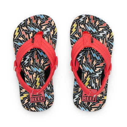 Little Ahi boys flip flops with red straps facing upward, featuring colorful bolt pattern, soft cushioning, and arch support.