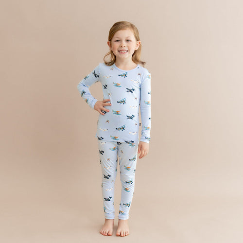 Young girl standing with one hand on her hip wearing the Long Sleeve Pajamas in Take Off