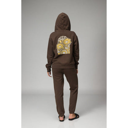 Person wearing brown Misty Fleece Full Zip hoodie back view with floral and rainbow design, paired with comfortable black sandals facing back