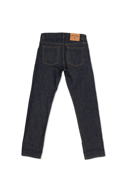 Back view of dark blue denim jeans with visible stitching and a brown leather patch on the waistband, isolated on white.