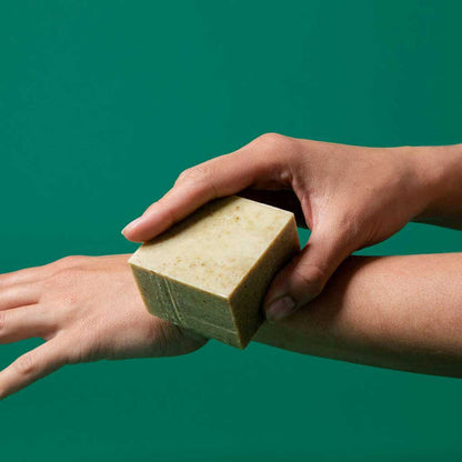 Sallye Ander Bug repellent and after-bite soap brushed against arm on dark green background