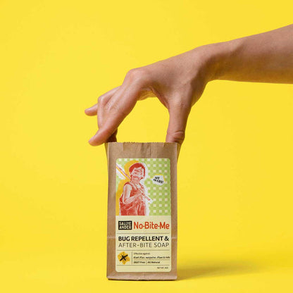 Hand reaching into bag of Sallye Ander Bug repellent and after-bite soap against yellow background