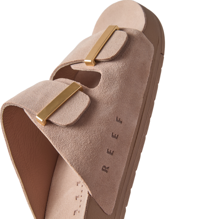 Ojai Two Bar women's sandal facing right, close-up on soft taupe suede upper with gold-tone buckles and embossed REEF logo