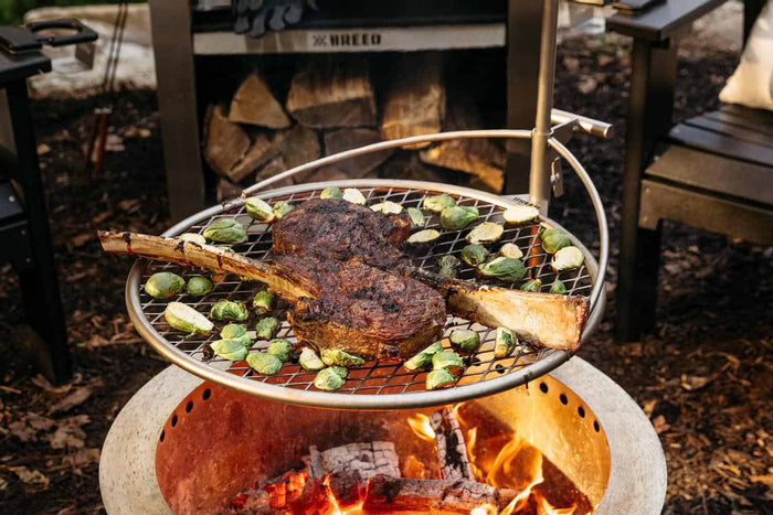 An image of Outpost 24 attached to an X Series firepit and used for grilling.