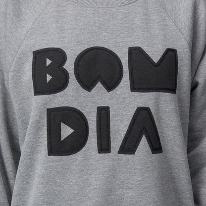 Close-up of the chest area on the women's Oversized Raglan Fleece in heather grey with bold black graphic letters.