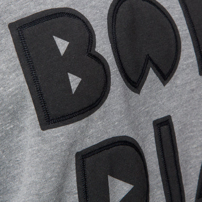 Close-up of the front chest embroidery on the Oversized Raglan Fleece in heather grey with soft, comfortable fabric.