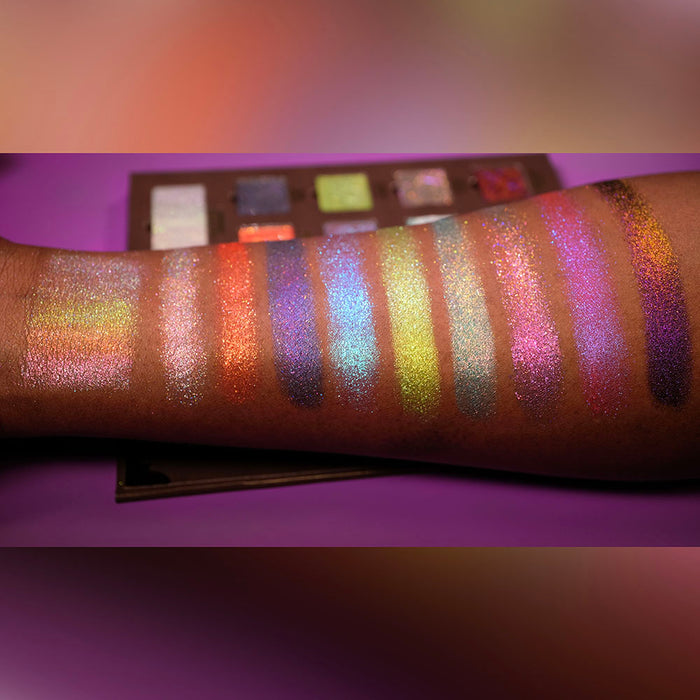 Swatches of all nine Pick Your Potion eyeshadows on deep coloured skin. Palette in background.