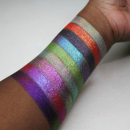 Swatches of all nine Pick Your Potion eyeshadows on deep coloured skin, on a white background.