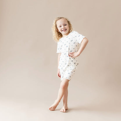 Young girl wearing a white outfit with small rose patterns on a beige background