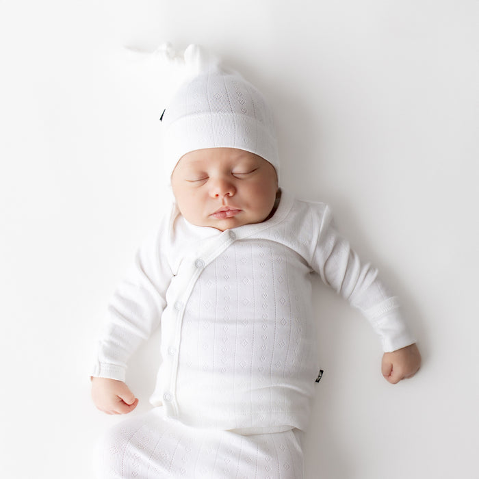 Close up of sleeping newborn wearing the Pointelle Take Me Home Set with Cap in Cloud