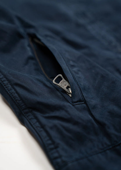 Close-up of a navy blue fabric with a partially open zipper, highlighting the texture and stitching details.