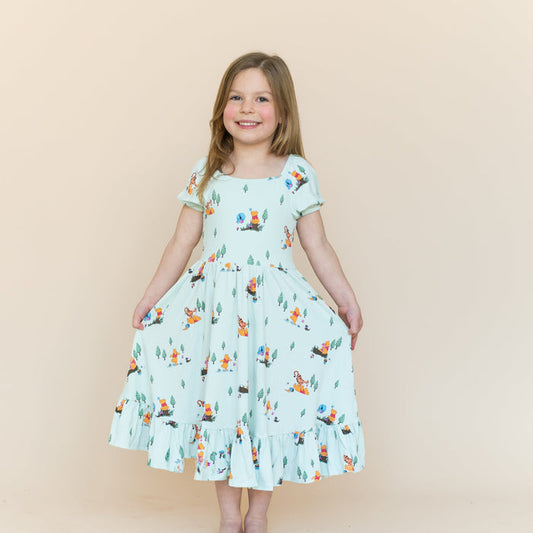 Young smiling girl wearing the Puff Sleeve Twirl Dress in Winnie the Pooh Hundred Acre Wood holding the skirt of the dress out