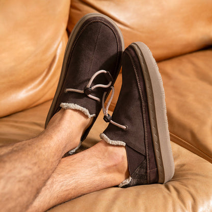 Rambler men's brown slip-on shoes facing left with cushioned sole and warm fleece trim, shown in relaxed setting.