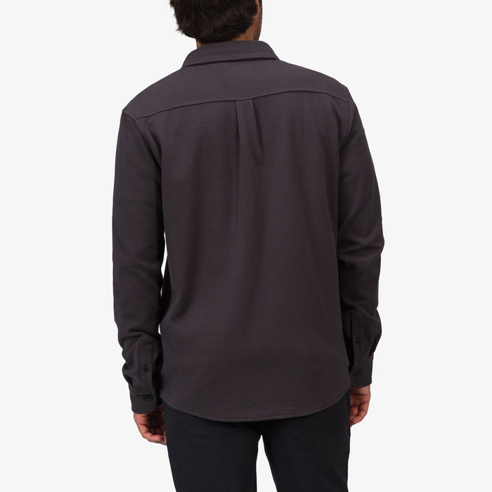 Back view of a man wearing the Raymond Ls Shirt in dark gray, showcasing its casual, surf-inspired comfortable apparel style.