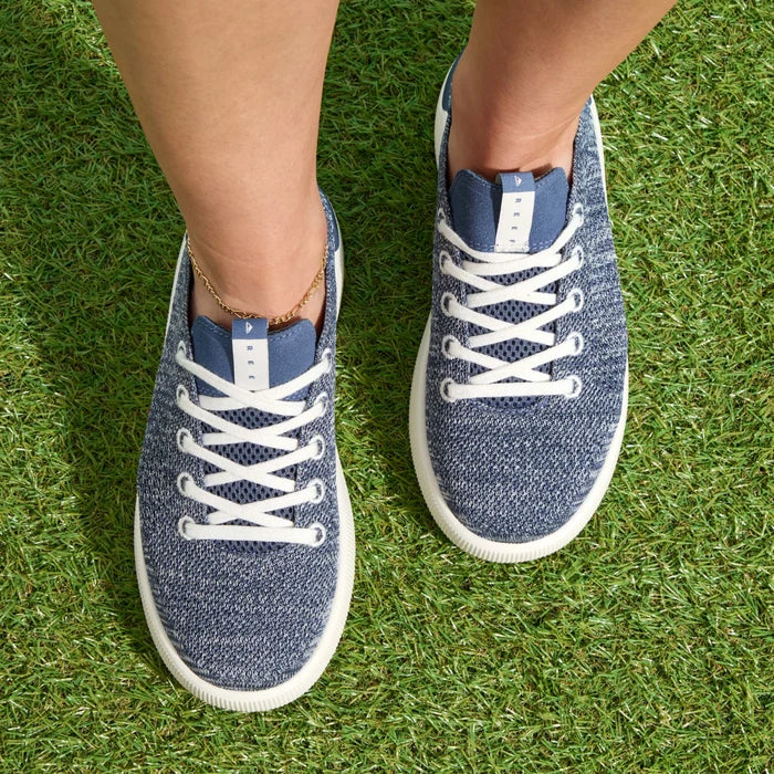 Top-down view of women's Reef Neptune sneakers facing forward on grass, featuring comfort and water-friendly materials.