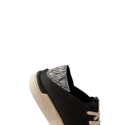 Reef Neptune women’s black sneaker facing left, showing heel with zebra print detail and lightweight sole.