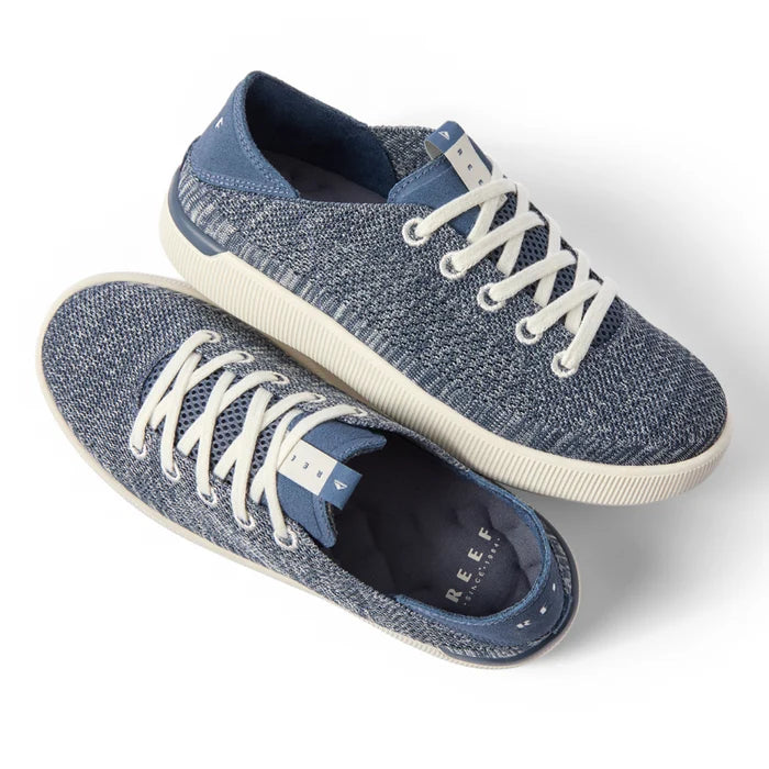 Pair of Reef Neptune women's sneakers shown from the top and right side in blue knit with white laces, designed for comfort and beach wear.