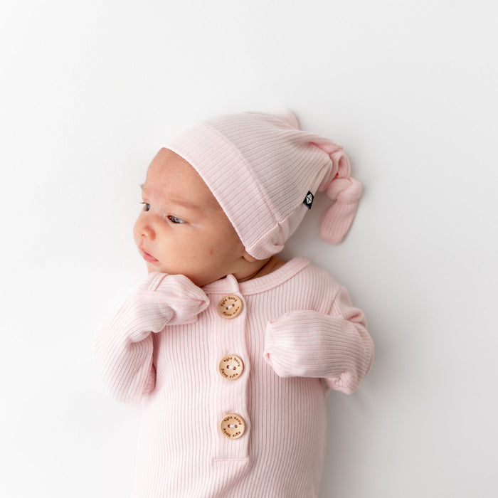 Newborn wearing Kyte Baby Ribbed Knotted Gown with Hat Set in Sakura PInk