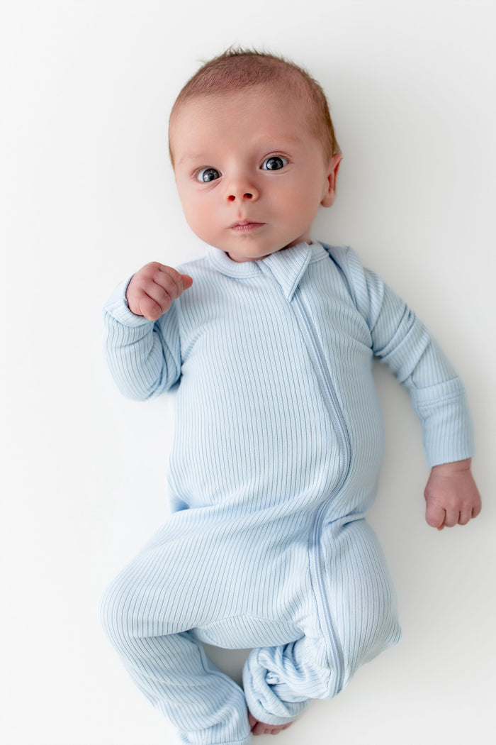 Close up of newborn wearing the Ribbed Zipper Romper in Breeze