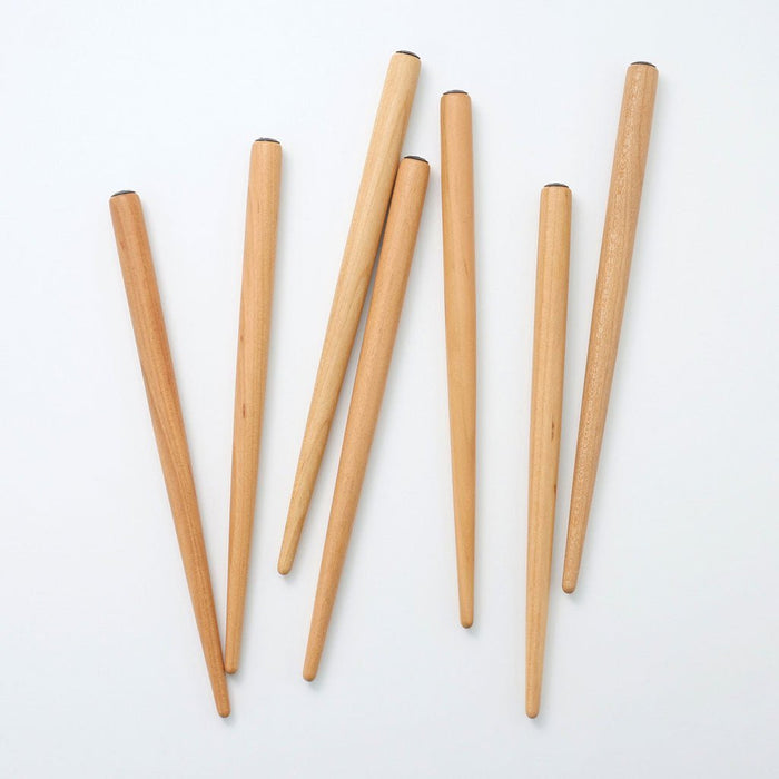 Pile of sakura wood nib holders on white surface