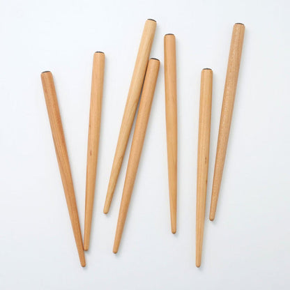 Pile of sakura wood nib holders on white surface