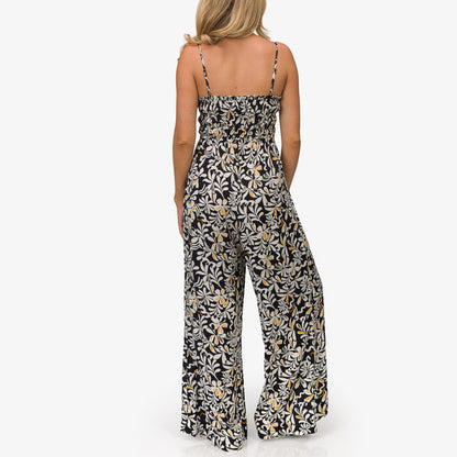 Woman wearing a black floral Sandy Romper shown from the back, featuring lightweight, beach-inspired comfort apparel.