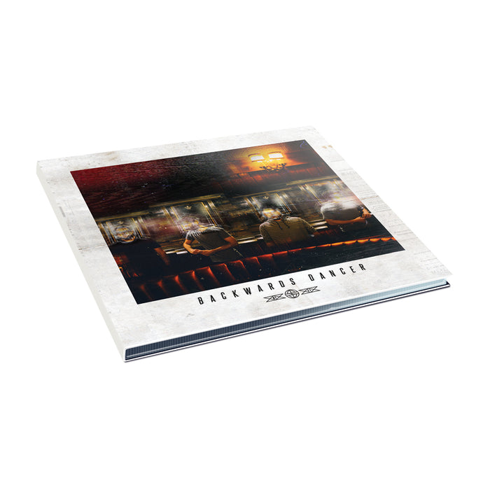 A vinyl record album cover by Backwards Dancer, showing four people seated on a red booth in a dim room, with the album title and "Radio Forever" printed beneath the photo.
