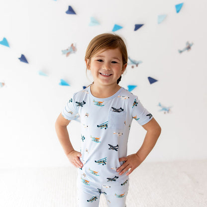 Close up of smiling girl standing with both hands on her hips wearing the Short Sleeve with Pants Pajamas in Take Off