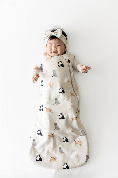 Smiling infant wearing he Sleep Bag in Fluffy Cat 1.0 with matching romper on underneath